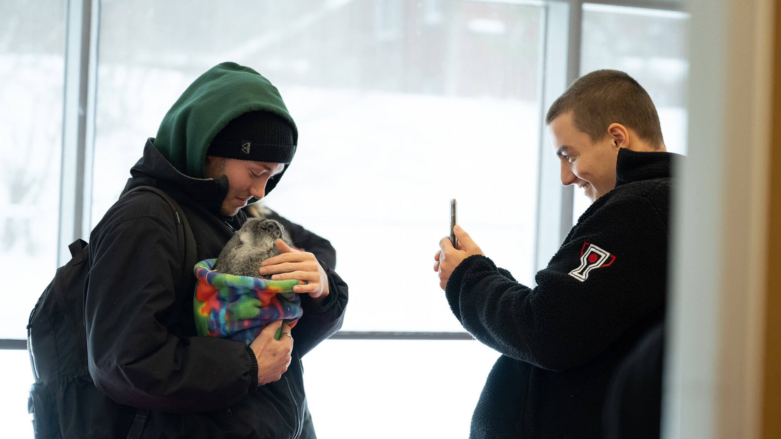 Deux étudiants participent à une séance de zoothérapie.